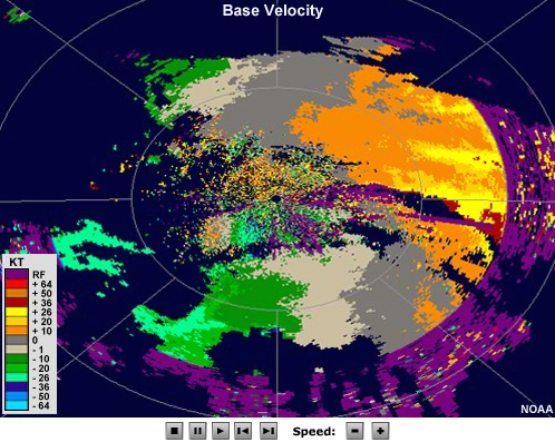 Radial velocity loop showing winds moving toward the radar on the left side of the image and away from the radar on the right. A small area to the southwest of the radar shows an initially divergent couplet that expands in size with time.